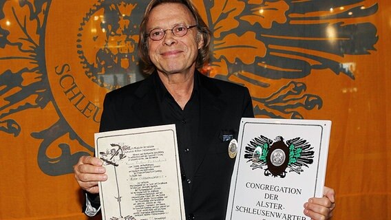 Der Schauspieler und Regisseur Volker Lechtenbrink posiert nach seiner Ernennung zum Ehren-Alster-Schleusenwärter. © dpa Foto: Malte Christians