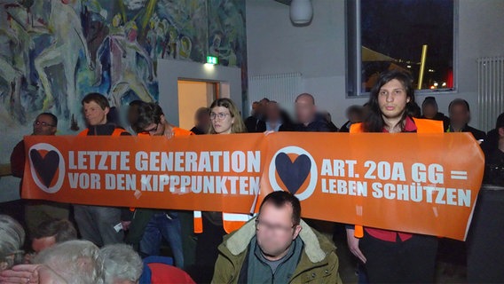 Aktivisten und Aktivistinnen der "Letzten Generation" halten ein Banner bei einer SPD-Veranstaltung in Hamburg-Lohbrügge hoch. © HamburgNews 