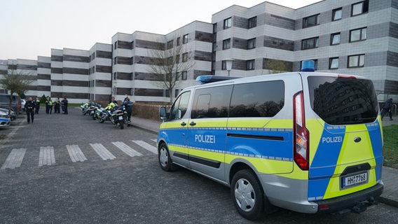 Ein Polizeiwagen und viele Beamte stehen vor der "Lindwurm-Siedlung" in Hamburg-Lohbrügge, in der Nacht wurde hier ein lebloser Mann gefunden. © CityNewsTV 