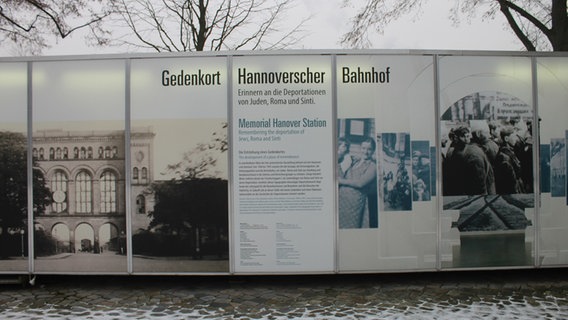 Auf einem Container mit der historischen Bahnhofsansicht steht "Gedenkort Hannoverscher Bahnhof". © NDR Foto: Daniel Sprenger