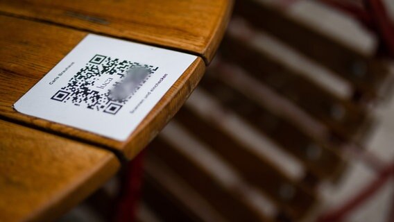 Ein QR-Code für das einchecken in der Luca-App ist auf einem Tisch eines Restaurants zu sehen. © dpa Foto: Christoph Schmidt