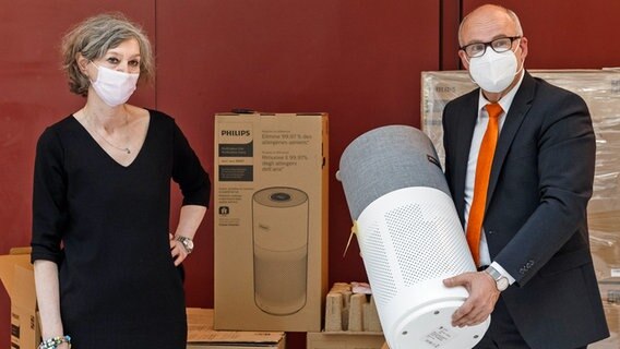 Ties Rabe (SPD), Schulsenator Hamurgs, zeigt mit Marion Bottek, Schulleiterin der Grundschule Richardstraße, das erste mobile Luftfiltergerät gegen Corona-Viren für eine Hamburger Schule. © picture alliancce / dpa Foto: Markus Scholz