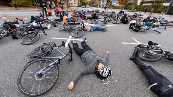 Dutzende Menschen haben sich mit ihren Fahrrädern für fünf Minuten auf die Unfallkreuzung gelegt. © picture alliance/dpa | Jonas Walzberg Foto: Jonas Walzberg