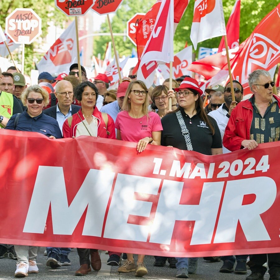 Demonstranten halten ein Transparent mit der Aufschrift "1.Mai 2024 Mehr Lohn, Freizeit, Sicherheit" in Hamburg-Altona. © picture alliance / dpa Foto: Georg Wendt