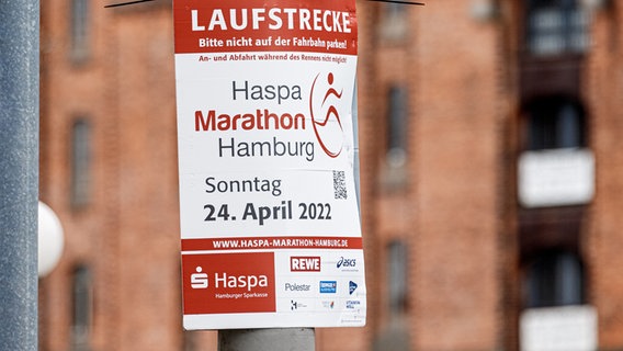 Ein Plakat weist auf die Sperrung einer Straße am 24.04.2022 für den Hamburg Marathon hin. © dpa Foto: Markus Scholz