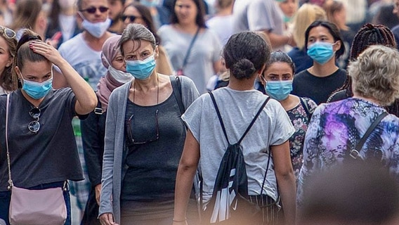 Zahlreiche Personen sind mit Masken unterwegs. © Picture Alliance Foto: Marius Becker