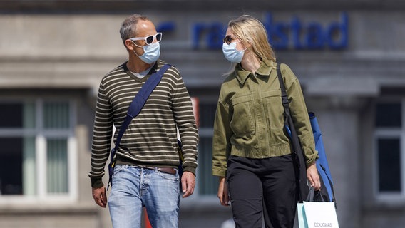Zwei Menschen gehen mit Maske durch eine Stadt. © picture alliance / Geisler-Fotopress Foto: Christoph Hardt