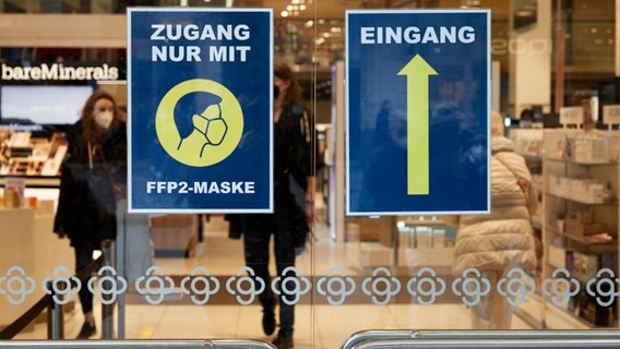 FFP2-Maskenpflicht im Einzelhandel: Ein Schild auf den Glastüren eines Kaufhauses weist darauf hin © picture alliance / rtn - radio tele nord Foto: picture alliance/dpa | Georg Wendt