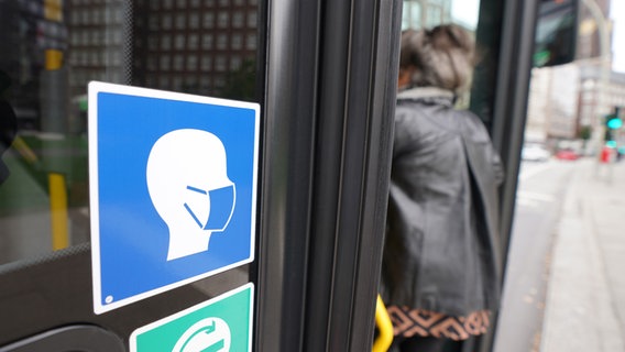 Ein Aufkleber an einem Hamburger Linienbus weist auf die Maskenpflicht im öffentlichen Personennahverkehr hin. © picture alliance / dpa Foto: Marcus Brandt
