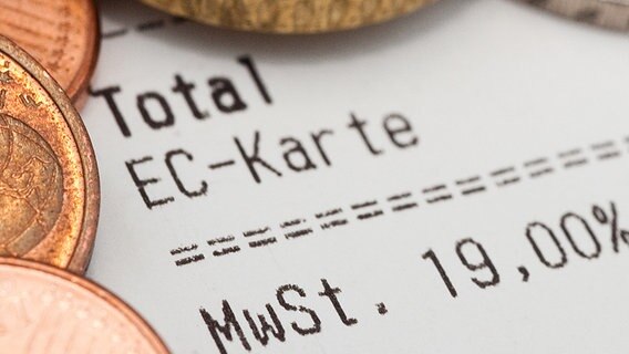 Geldstücke liegen auf einem Kassenbon, auf dem die Mehrwertsteuer zu sehen ist. © dpa Foto: Andrea Warnecke
