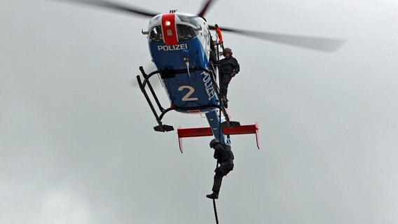 Ein MEK-Beamter seilt sich von einem Helikopter ab. © Carolin Fromm/NDR Foto: Carolin Fromm
