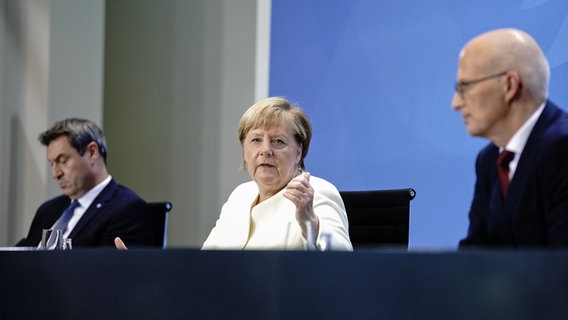 Bundeskanzlerin Angela Merkel (CDU), Markus Söder (CSU - l), Ministerpräsident von Bayern und CSU-Vorsitzender, und Peter Tschentscher (SPD), Erster Bürgermeister von Hamburg, geben eine Pressekonferenz. © picture alliance/dpa Foto: Kay Nietfeld