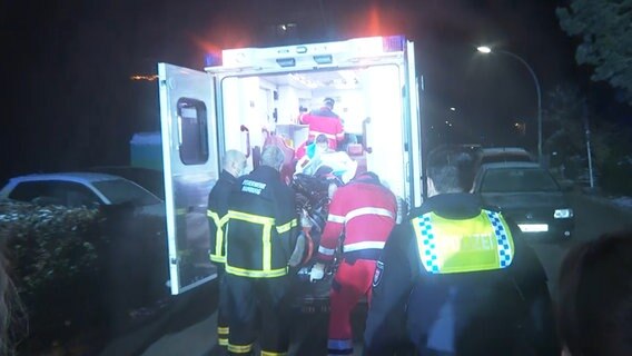 In Rahlstedt ist eine Frau durch Messerstiche schwer verletzt worden. Feuerwehr und Polizei sind im Einsatz. Die verletzte Frau wird in einen Krankenwagen gebracht. © tv news kontor 