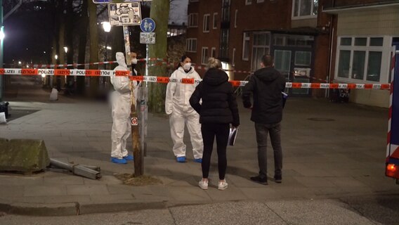 Einsatzkräfte der Polizei stehen in der Nacht in Hamburg beisammen. © TNN Foto: Screenshot