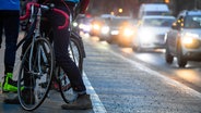 Ein Fahrradfahrer steht während des Berufsverkehrs neben einem Radweg. © picture alliance/Andreas Arnold Foto: Andreas Arnold