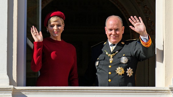 Fürst Albert II. von Monaco und Fürstin Charlène stehen am Balkon des Palastes von Monaco. © Daniel Cole/AP/dpa 