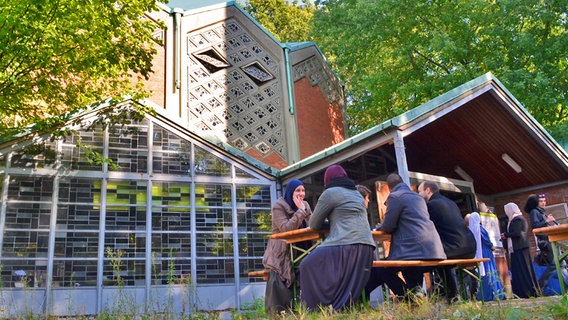 Menschen sitzen vor der ehemaligen Kapernaum-Kirche in Hamburg-Horn © NDR Foto: Anne Arend