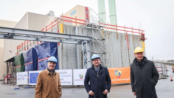Jens Kerstan (Bündnis90/Die Grünen, M), Senator für Umwelt und Energie in Hamburg, Rüdiger Sichau (l), Geschäftsführer Stadtreinigung Hamburg, und Michael Beckereit, technischer Geschäftsführer Wärme Hamburg GmbH, stehen vor einer Baustelle auf dem Gelände der Müllverwertungsanlage Borsigstraße (MVB).  Foto: Christian Charisius