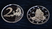 Zwei neue Zwei-Euro-Münzen mit der Silhouette der Elbphilharmonie. © picture alliance / dpa Foto: Christian Charisius