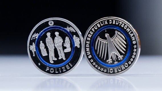 Zwei neue Zehn-Euro-Gedenkmünzen "Polizei" stehen auf einem Tablett. © Christian Charisius/dpa 