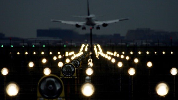 Ein Flugzeug landet im Dunkeln am Flughafen. © picture-alliance / dpa Foto: Maurizio Gambarini