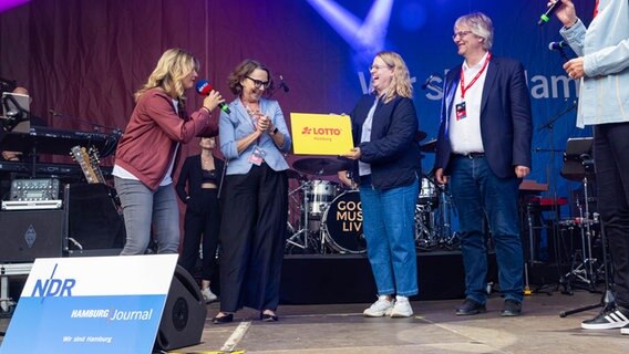 Am 23. Juli 2022 übergeben Moderatorin Nicole Steins (li.) und eine Mitarbeiterin von Lotto Hamburg einen Scheck an den Förderkreis Erlenbusch. © NDR Foto: Axel Herzig