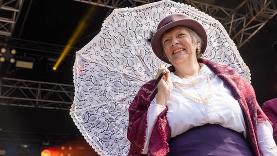 Eine Frau mit weißem Schirm und historischem Kostüm © NDR Foto: Axel Herzig