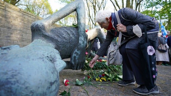 Eine Frau legt nach der Gedenkfeier anlässlich des 77. Jahrestages des Kriegsendes und der Befreiung der Häftlinge in der KZ Gedenkstätte Neuengamme in Hamburg eine Rose am Mahnmal ab. © picture alliance / dpa Foto: Marcus Brandt