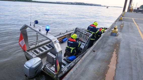 Feuerwehrleute suchen von einem Motorboot aus das Wasser der Elbe unter dem Anleger Teufelsbrück nach einem 13-Jährigen ab. © picture alliance/dpa Foto: Jonas Walzberg