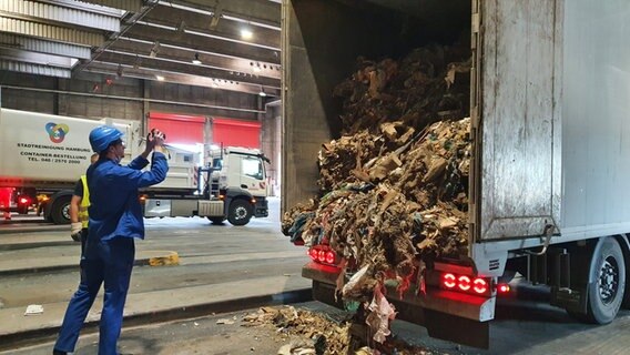 Ein Mitarbeiter der Stadtreinigung Hamburg begutachtet aus Nordrhein-Westfalen angelieferten Müll. © Stadtreinigung Hamburg 