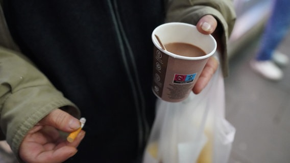 Arme einer obdachlosen Frau, die Kaffee und Zigarette in der Hand hält. © picture alliance/dpa | Marcus Brandt Foto: Marcus Brandt