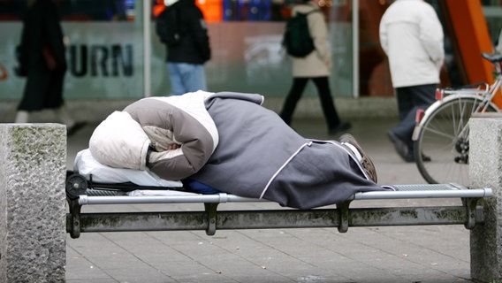 Ein Obdachloser liegt bei Minus-Graden auf einer Bank in der Hamburger Innenstadt © dpa Foto: Kay Nietfeld