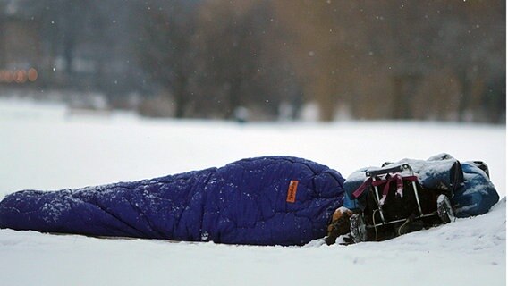 Ein Obdachloser liegt an der Hamburger Außenalster im Schnee. © dpa Foto: Kay Nietfeld
