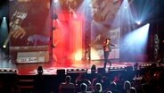 In der Show "Oberaffengeil" im Schmidt Theater interpretiert ein Darsteller, im Scheinwerferlicht auf der Bühne stehend, den Song "I’ve Been Looking for Freedom". © NDR/Screenshot 
