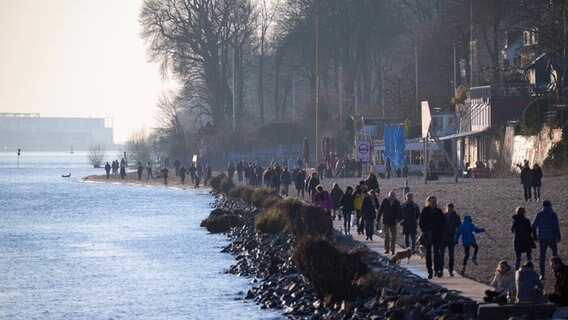 Spaziergänger genießen klares Frühlingswetter an der Elbe. © picture alliance/dpa Foto: Jonas Walzberg