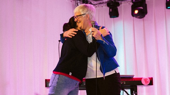 Mitra Kassai und Dagmar Hirche umarmen sich auf der Bühne. © kukuun Foto: Jonas Krantz