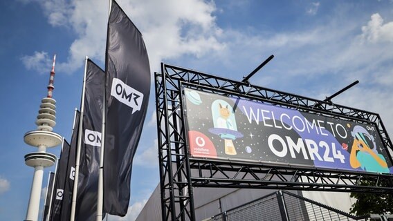 "Welcome to OMR24“" steht über dem Eingang zur Digital- und Marketingmesse Online Marketing Rockstars OMR in den Messehallen. © picture alliance/dpa Foto: Christian Charisius