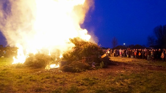 Menschen betrachten ein Osterfeuer in Hamburg. (Archivfoto) © picture alliance /ABBfoto 