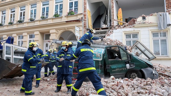 Nach dem Einsturz einer Fassade in Hamburg-Ottensen räumen Einsatzkräfte weg. © picture alliance/dpa Foto: Bodo Marks