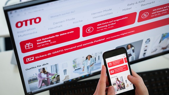 Ein Mann hat die Webseite und die Smartphone-App mit dem Onlineshop von Otto.de geöffnet. © dpa Foto: Christian Charisius