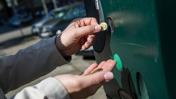 Eine junge Frau bezahlt in Hamburg ein Ticket am Parkscheinautomaten. © picture alliance / dpa Foto: Christin Klose