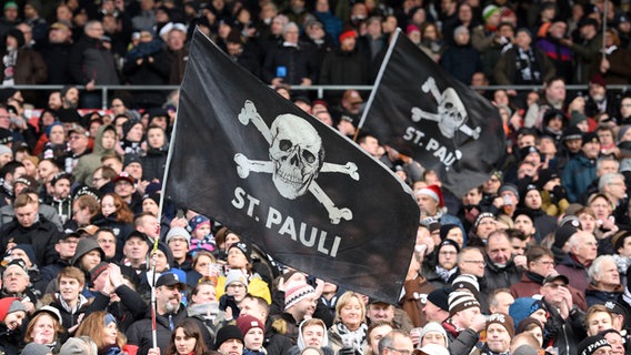 Fans des FC St. Pauli schwenken ihre Fahnen. © picture alliance/dpa Foto: Daniel Bockwoldt