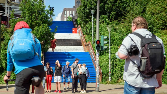 Menschen gehen an der Davidtreppe im Hamburger Stadtteil St. Pauli entlang. Unbekannte hatten die Stufen in den HSV-Farben Blau, Weiß und Schwarz bemalt. © picture alliance/dpa Foto:  Gregor Fischer