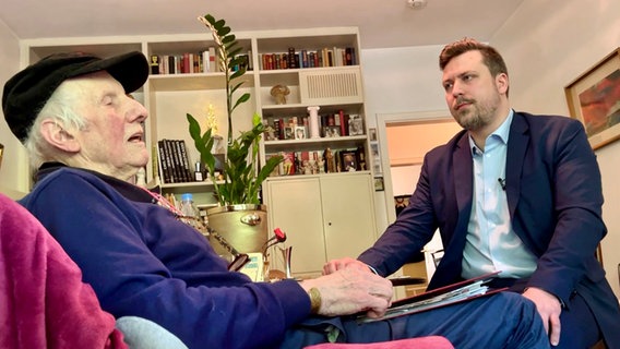 Rentner Horst Peinemann sitzt mit seinem Rechtsanwalt Dirk Drieschner in seiner Wohnung. © NDR 