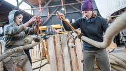 Die Rigger Carla Enchelmaier (li.) und Finn Goggen arbeiten im Hafenmuseum Hamburg an der Takelage des Museumsschiffs "Peking". © dpa - Bildfunk Fotograf: Daniel Bockwoldt/dpa