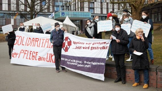 Teilnehmende einer Kundgebung von "Hamburger Bündnis für mehr Personal im Krankenhaus" und Verdi Betriebsgruppe Universitätsklinikum Eppendorf (UKE) stehen vor dem Haupteingang des Klinikums . © picture alliance/dpa | Georg Wendt Foto: Georg Wendt