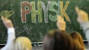 Schüler melden sich vor einer Tafel mit der Aufschrift "Physik". © dpa Foto: Armin Weigel
