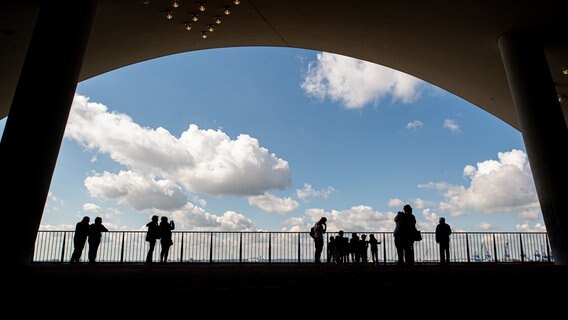 Besucher stehen auf der Plaza der Elbphilharmonie. Für den Besuch der beliebten Aussichtsplattform in der Hamburger Elbphilharmonie könnte bald Eintritt fällig werden.  Foto:  Daniel Reinhardt