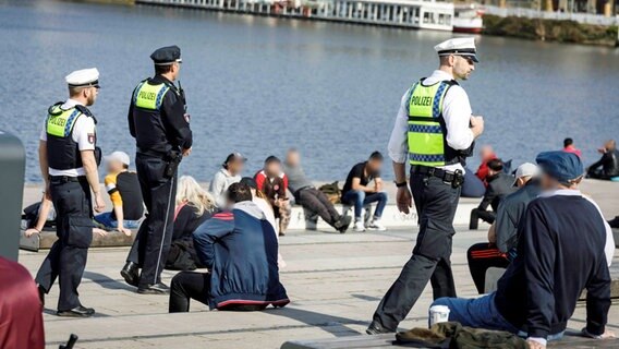 Polizisten kontrollieren in Hamburg am Jungfernstieg, ob die Corona-Regelungen eingehalten werden. © imago 