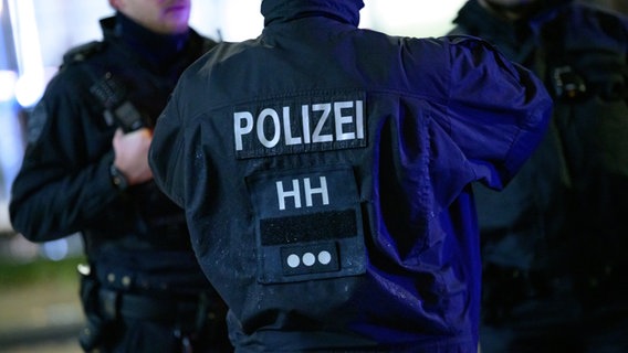 Hamburger Polizisten stehen an einem Tatort und besprechen sich. © picture alliance / dpa Foto: Jonas Walzberg